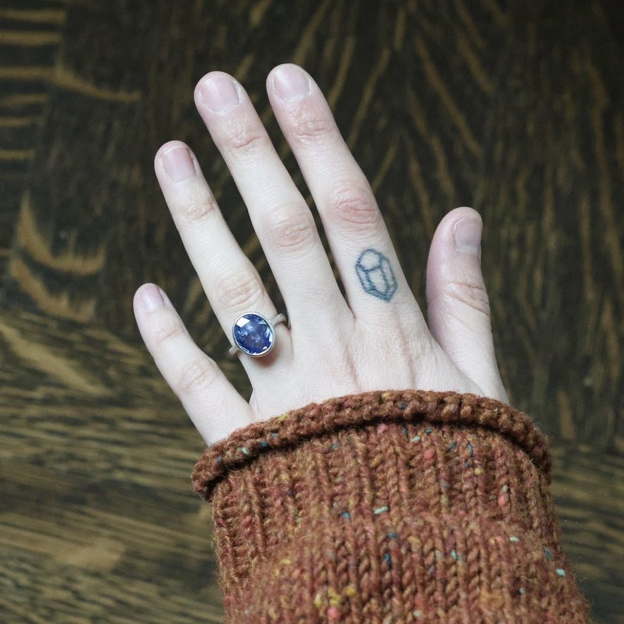 Handcrafted sapphire ring worn on a hand